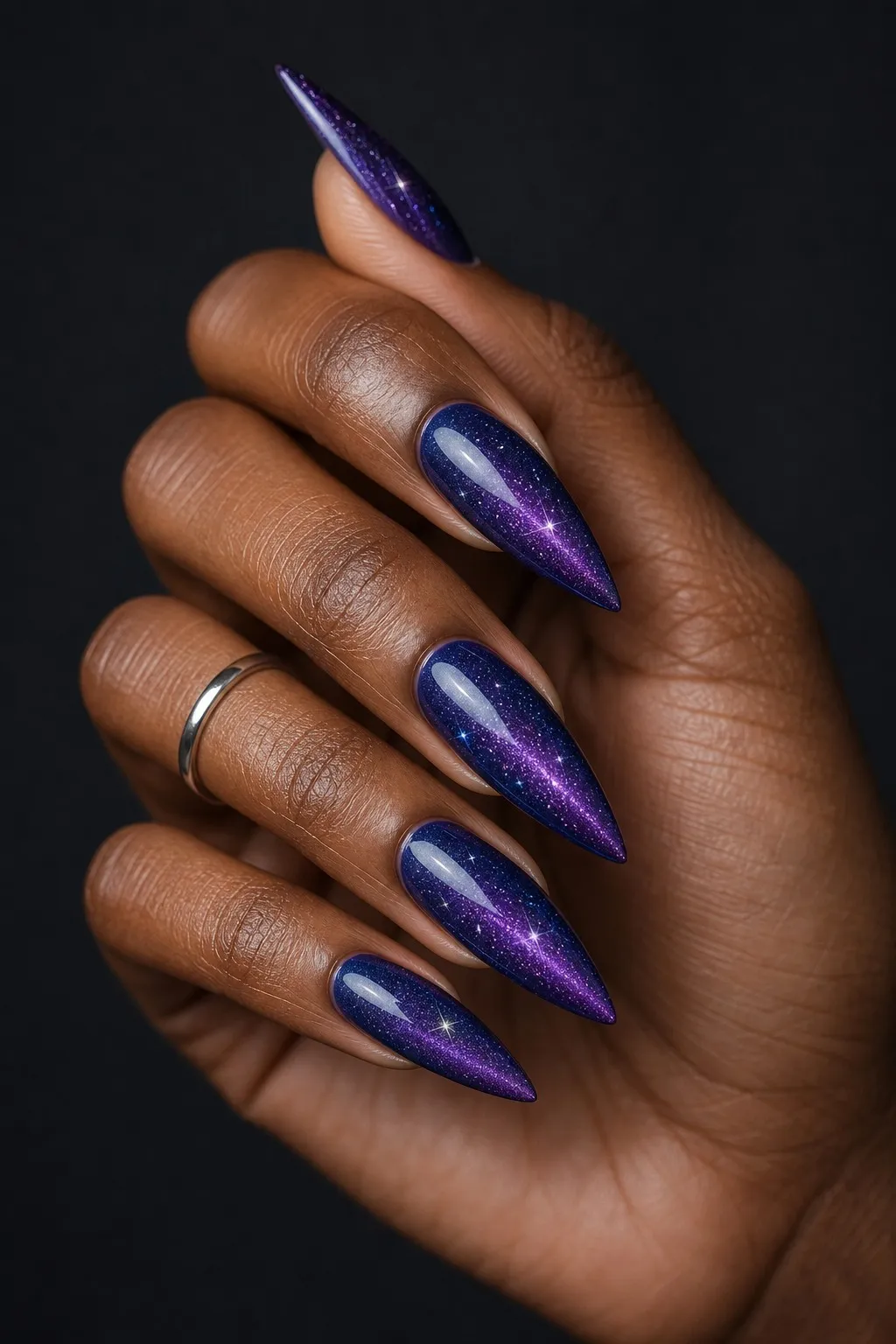 Galaxy Blue Stiletto — stiletto cat eye nails with cobalt-to-violet magnetic cat-eye with a scattered silver flash, magnet moved for a starry…