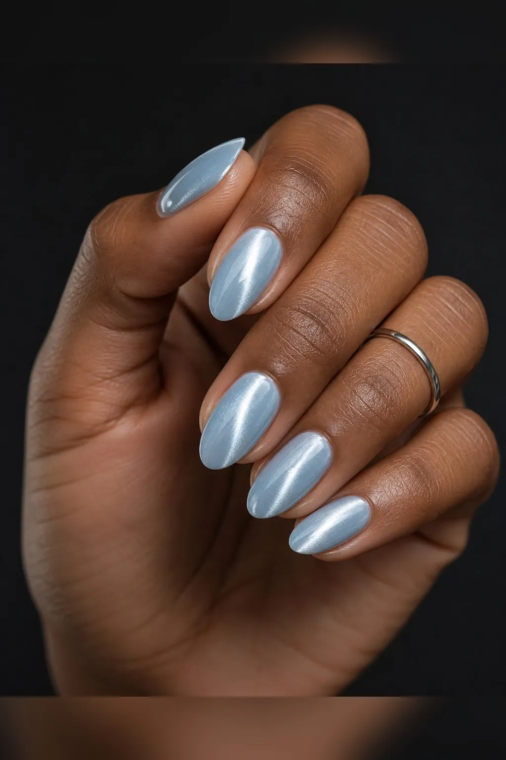 Ice Blue Cat-Eye — almond cat eye nails with pale ice-blue magnetic cat-eye polish with a silver-white flash, soft vertical line, glossy…