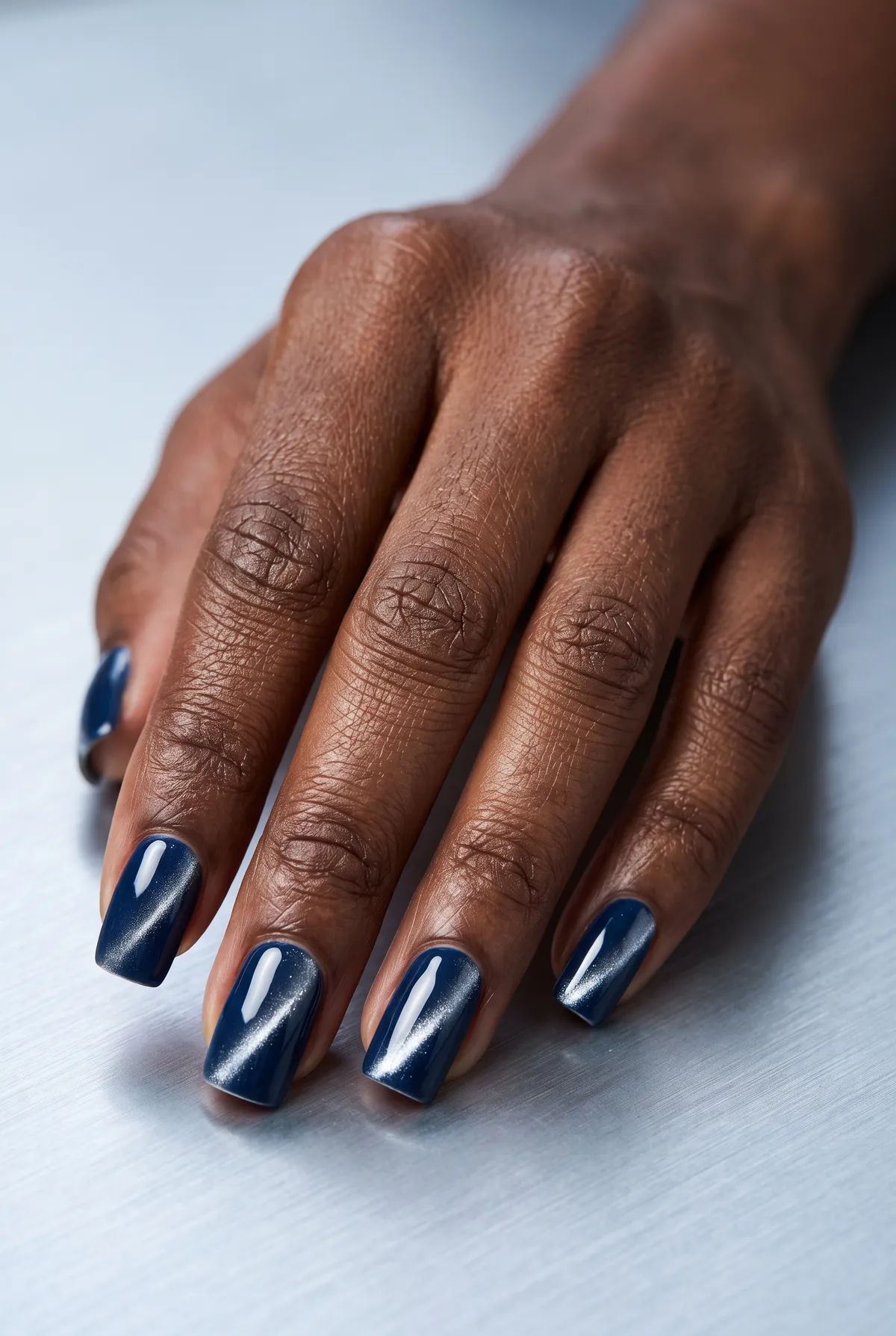 Sapphire Line — square cat eye nails with apply a navy gel base, sweep a silver magnetic top coat straight down the center, square off the…