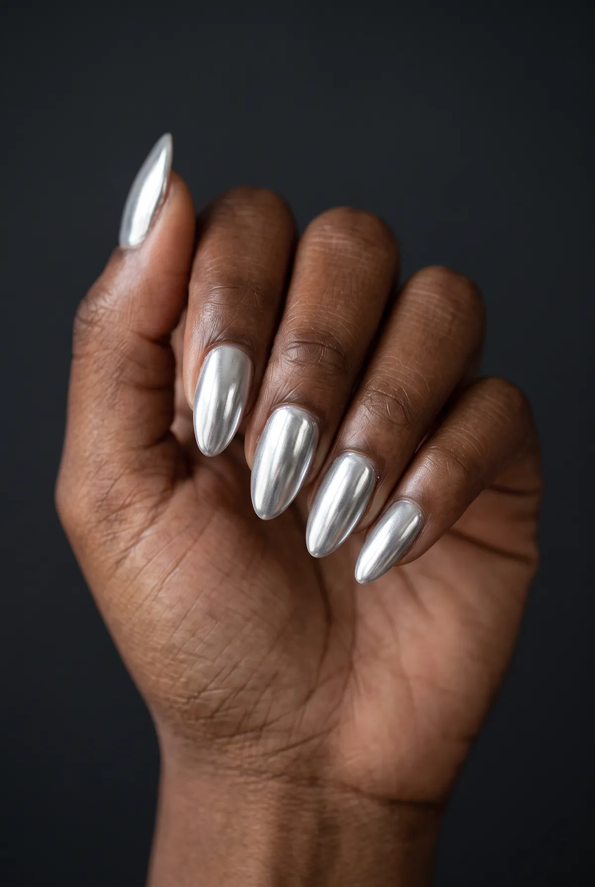 Liquid Mirror — almond chrome nails with clear gel base, full silver chrome powder over every nail, glossy sealed top coat, almond shape