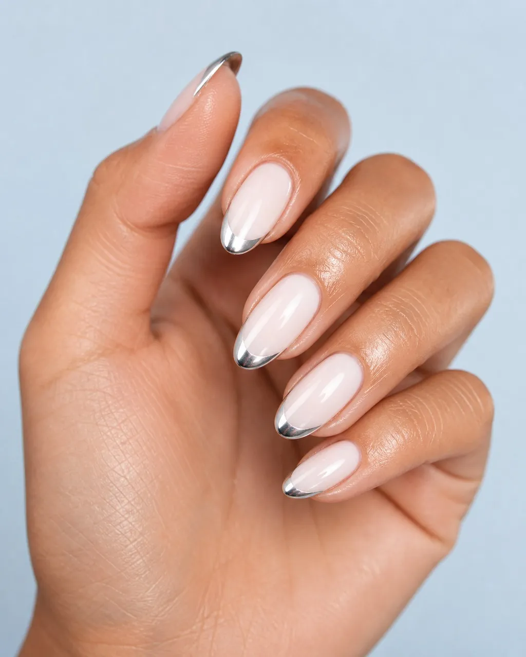 Silver Chrome French — almond chrome nails with sheer milky base with mirror-silver chrome powder on the french tips only, crisp smile line…