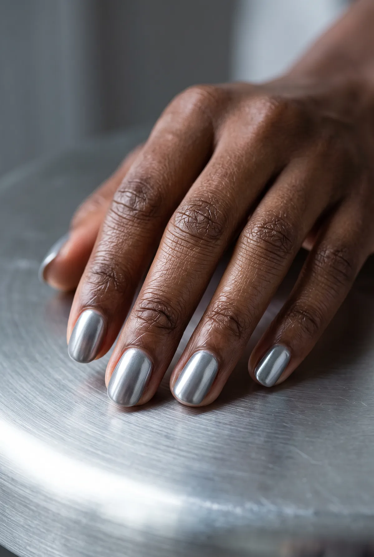 Titanium Everyday — round chrome nails with grey-based gel with titanium chrome powder, matte-adjacent glossy seal, short round shape
