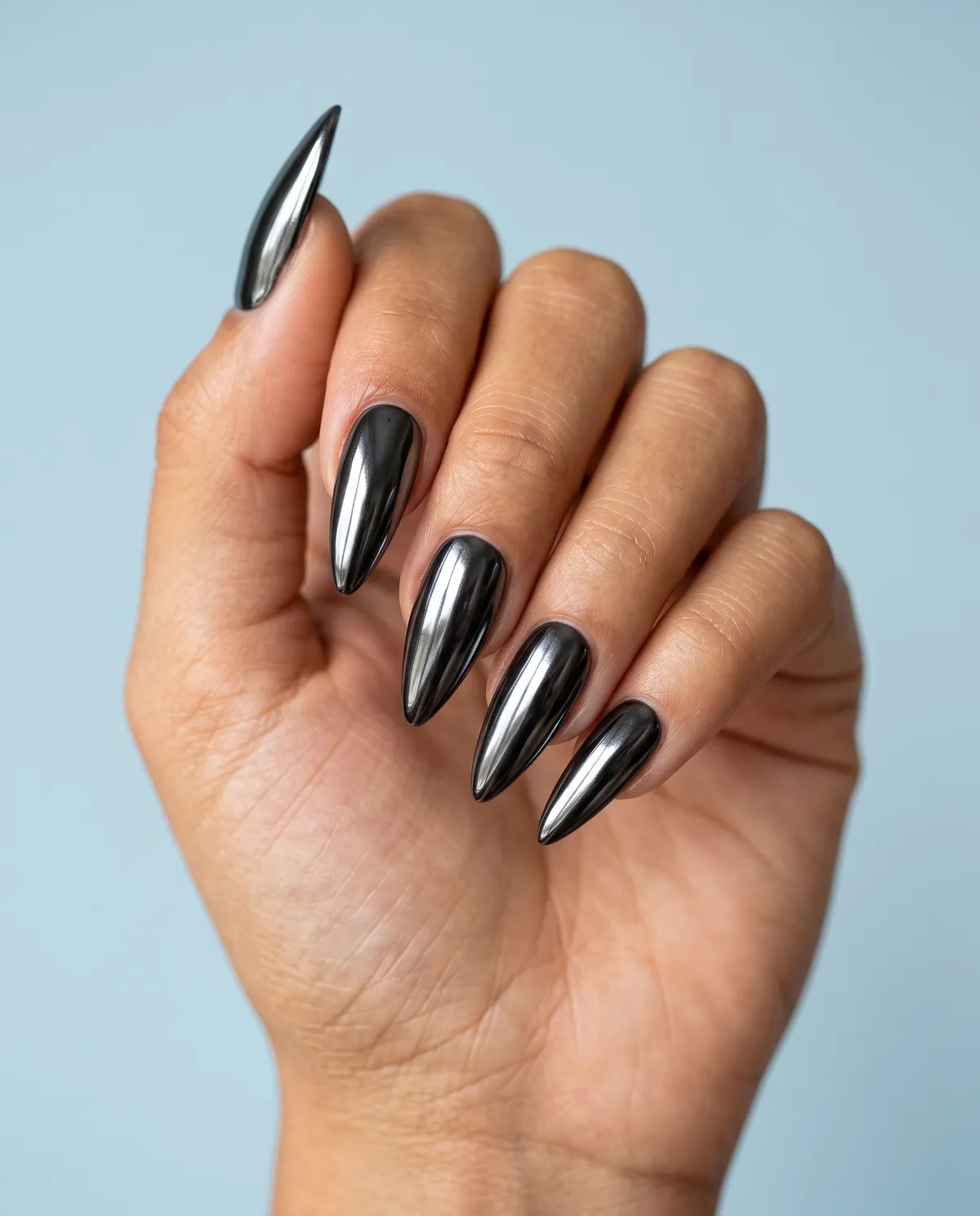 Onyx Mirror Talon — stiletto halloween nails with apply a black chrome mirror powder over a black gel base on long stiletto nails, high-shine…