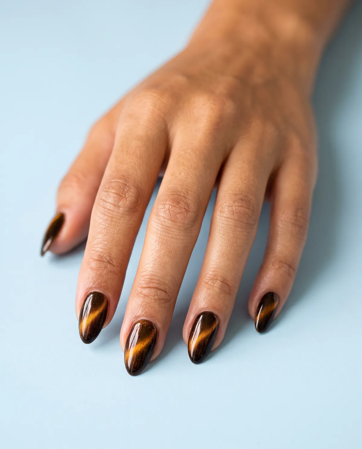 Werewolf Amber Eye — almond halloween nails with apply an amber-gold magnetic cat-eye gel on almond nails and pull the shimmer line before curing