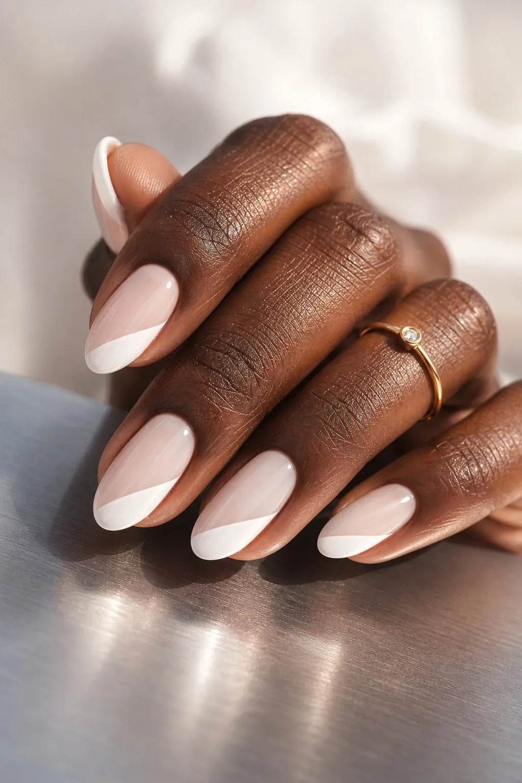 Diagonal French — almond french nails with sheer milky base with a white french tip painted as a clean diagonal across the tip, glossy…