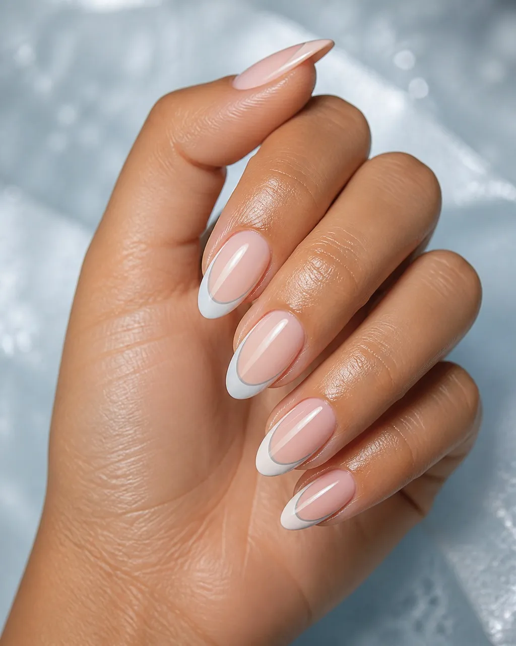 Frost Tip Negative Space — almond winter nails with sheer natural base with a frosted-white tip framed by a thin bare outline, glossy, medium…