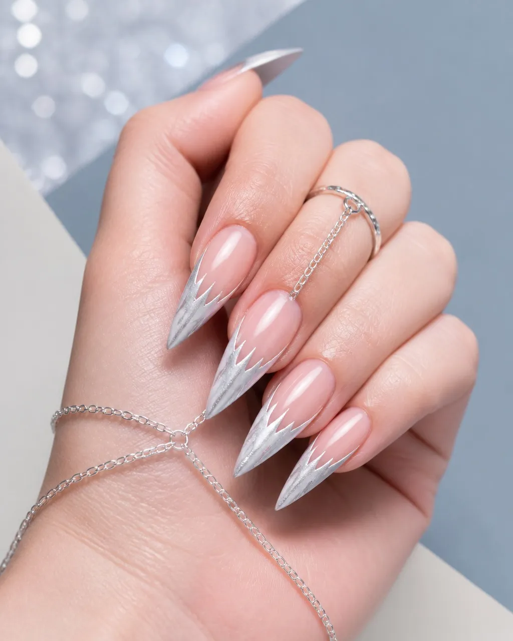 Icicle French — stiletto winter nails with sheer natural base with a silver-white french tip painted as a jagged icicle point, glossy, long…