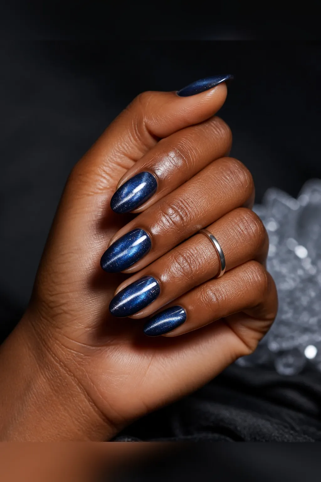 Midnight Blue Cat-Eye — almond winter nails with deep midnight-blue magnetic cat-eye gel with a straight silver centre flash, glossy seal…