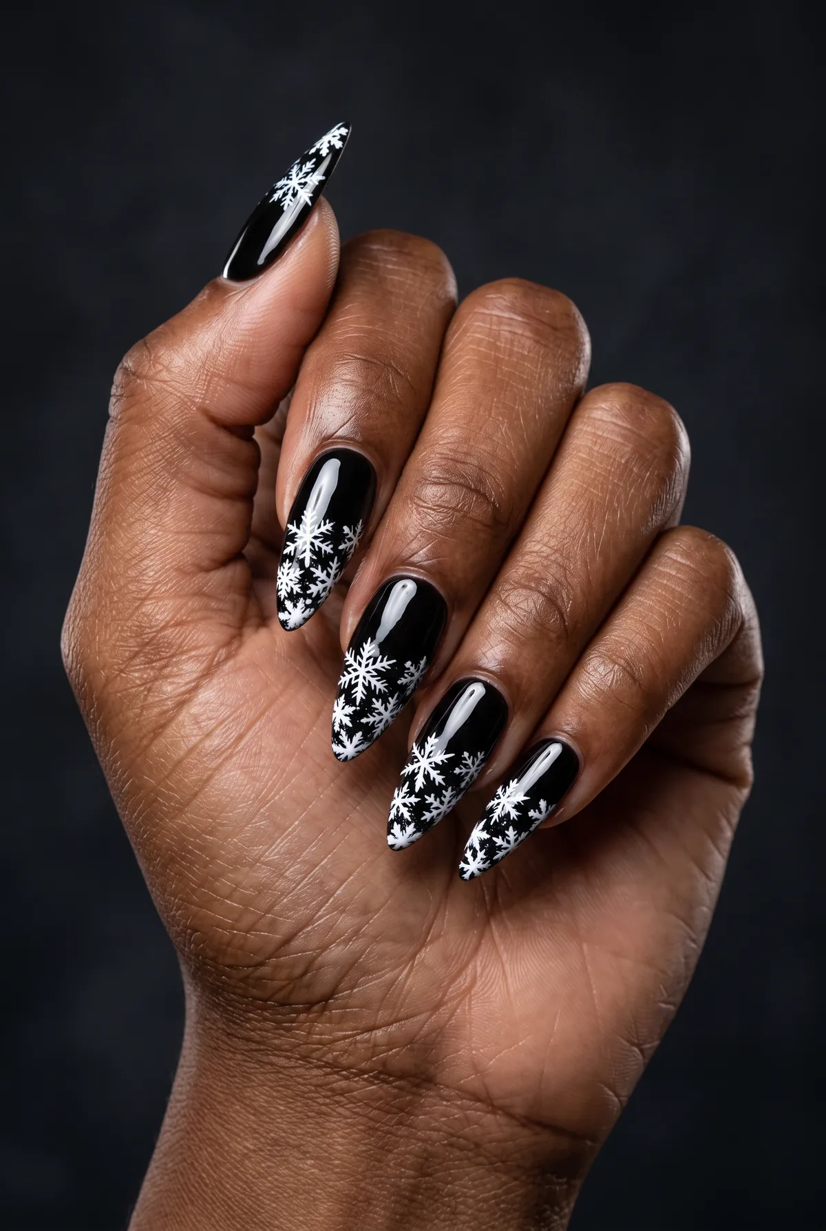 Onyx Snowfall — stiletto winter nails with stiletto shape, long length, black base, hand-paint white snowflakes clustered at the tip, seal…