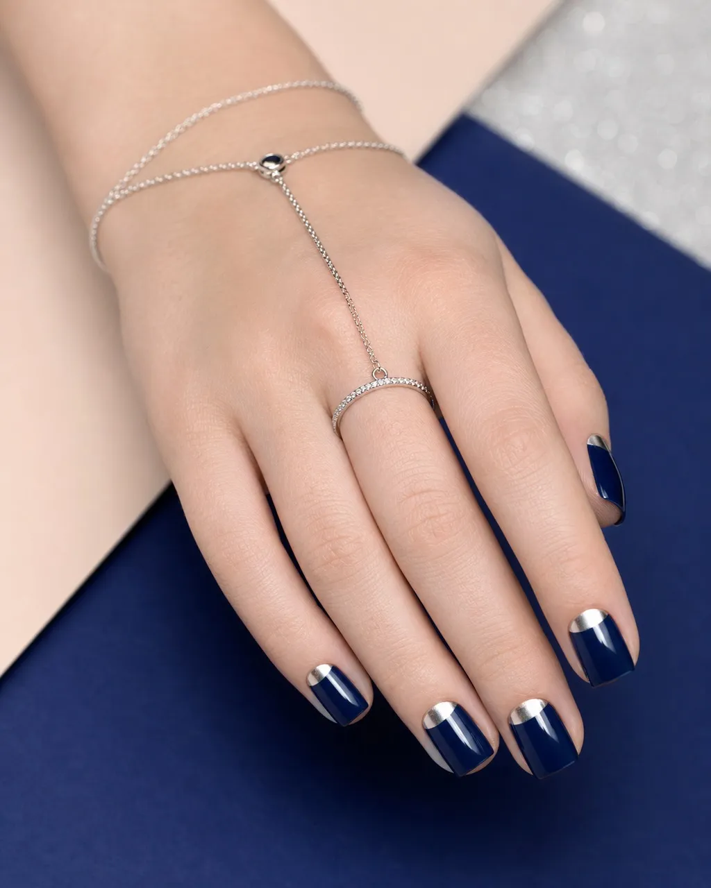 Silver Half-Moon — square winter nails with deep navy crème with a crisp silver chrome half-moon at the cuticle on every nail, glossy, short…